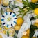 Lemons with branches and leaves arranged on lemon printed table linens with decorative plates and illuminated candles
